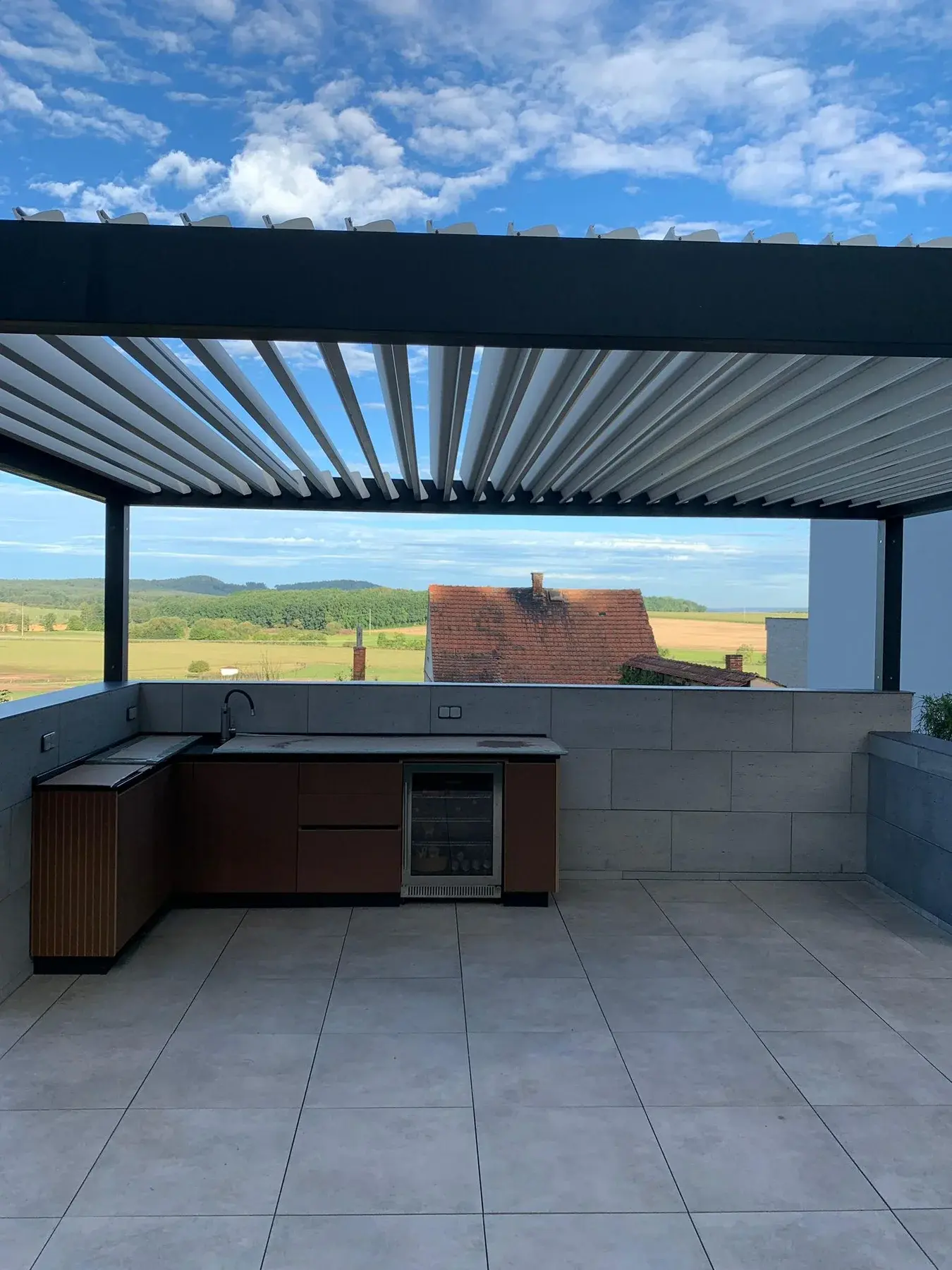 Hotová bioklimatická pergola s venkovní kuchyní a výhledem do krajiny